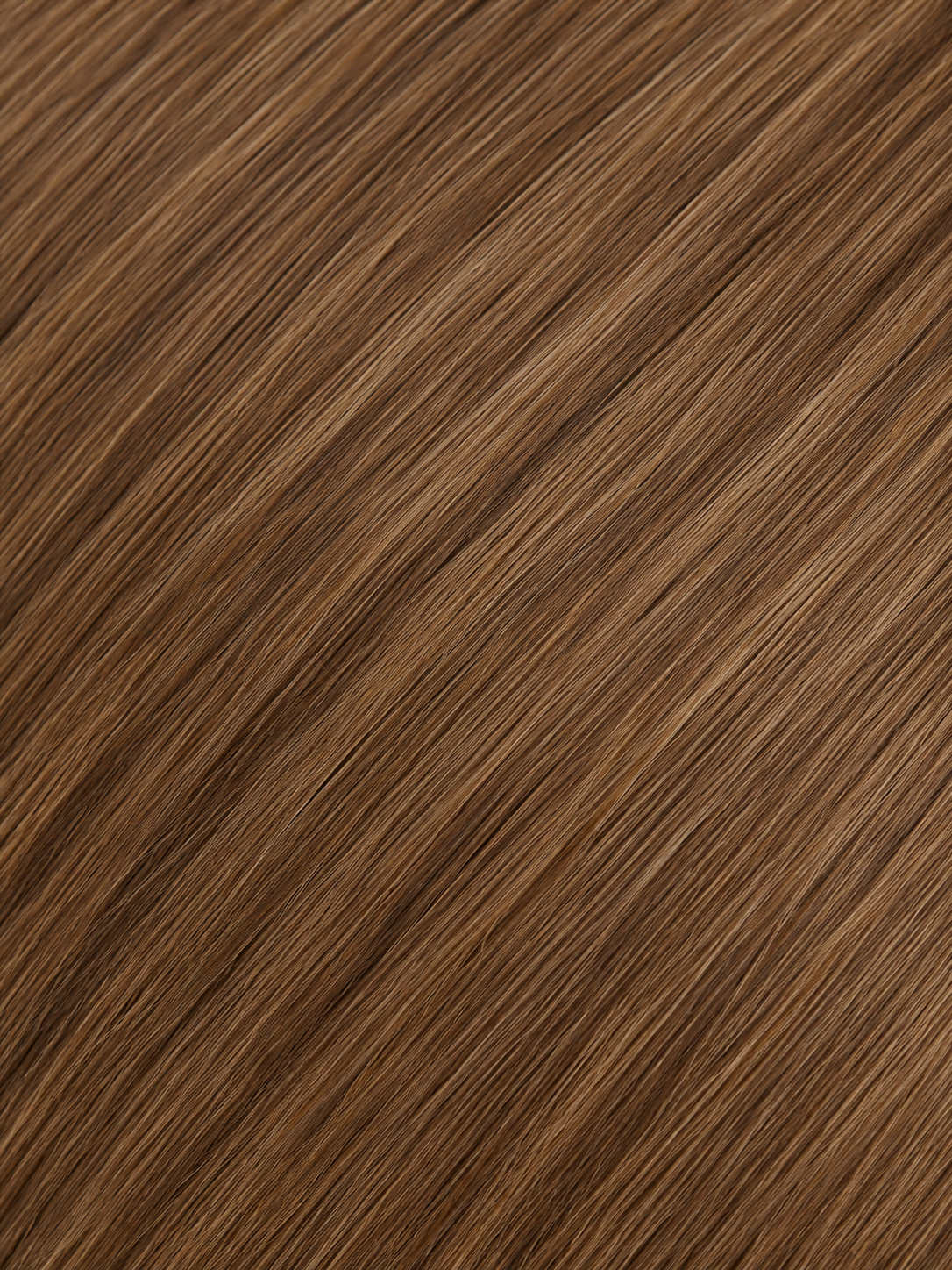 A close-up texture shot of straight brown hair with subtle warm caramel undertones, filling the entire frame.